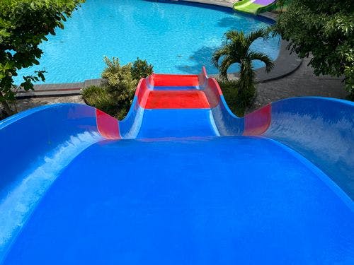 Point of view image going down a blue and red water slide into a pool