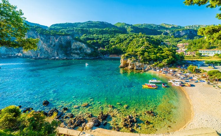 The beautiful natural cove of Paeleokatstritsa in Corfu, with a arched white sand beach surrounded by verdant forests and sea cliffs