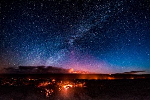 The Milky Way and stars over smoldering volcanoes in Hawaii