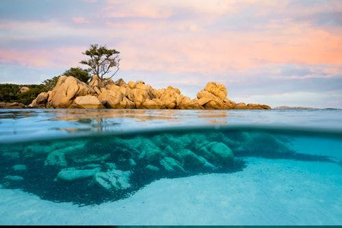 An above and below water shot of the rocky coast of Sardinia