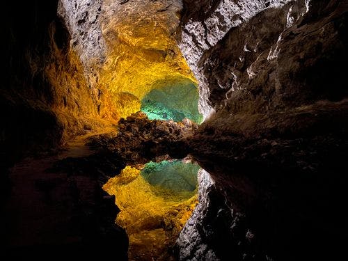 Cuevas de los Verdes lava tunnel with still water reflecting the rocky walls of the tube