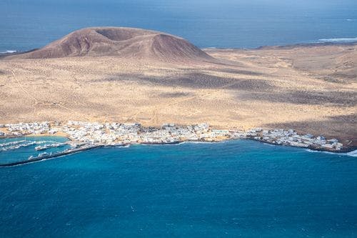 La Graciosa island, with a volcanic cone and small town by the sea