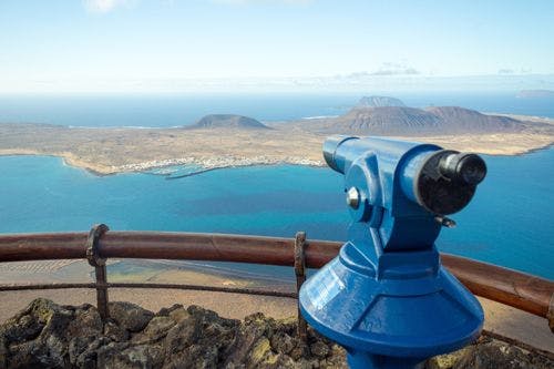 Mirador del Rio viewpoint with blue telescope overlooking nearby La Graciosa island