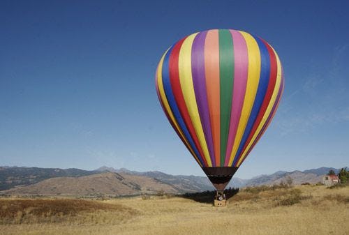 A colorful hot air balloon preparing for take off in the desert