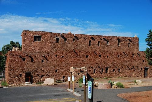 A pueblo house with red stone walls