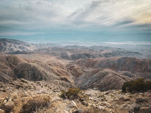 View of the desert of Coachella Valley with barren rocky mountains rising from the sand
