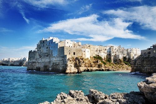 White buildings on a cliff over the sea in Puglia