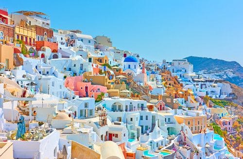 Oia village with traditional white and pale-colored buildings on a cliffside