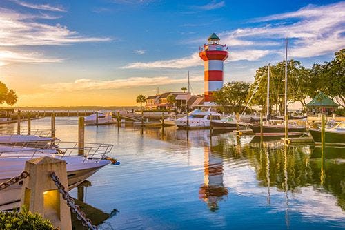 A white and red striped lighthouse by the water on Hilton Head Island