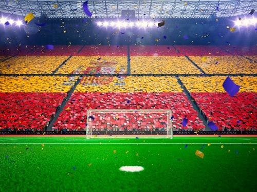 Fans in a football stadium wearing the colors of the Spanish flag