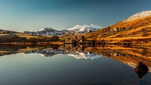 Reflection of Mount Snowden, Wales' tallest mountain, in a still lake 