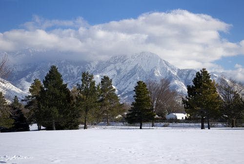 Winter landscape at Utah Olympic Park with snow covered field and mountains