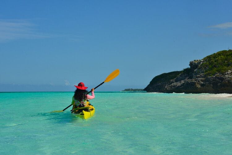 A female kayaker heads out to explore the ocean off Chalk Sound