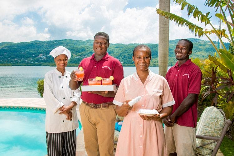 A team of staff at a villa smile for the camera. 144-calypso-shore