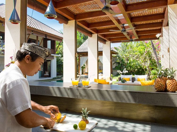 A chef chops tropical fruit in a private bar