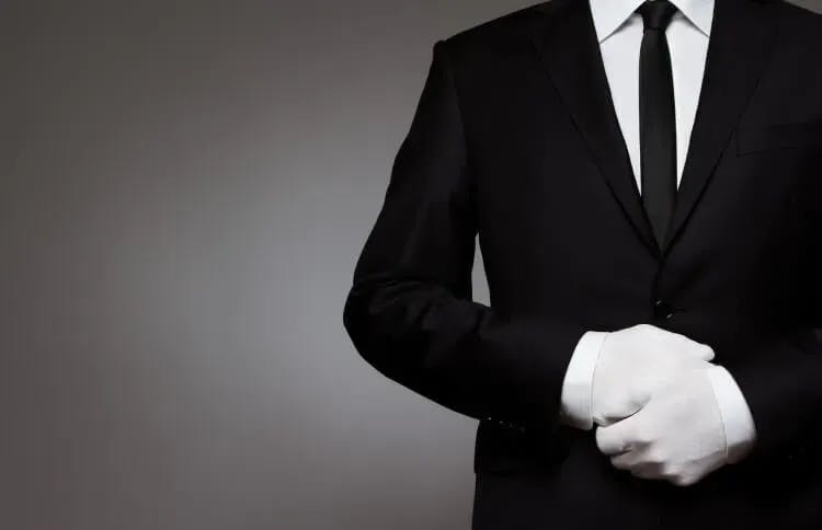 A butler with a black suit and white gloves