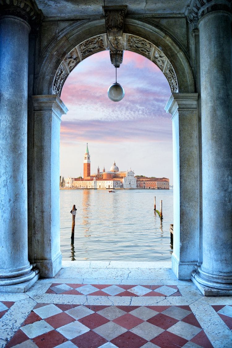 Scenic view of the Venice lagoon and church through an archway