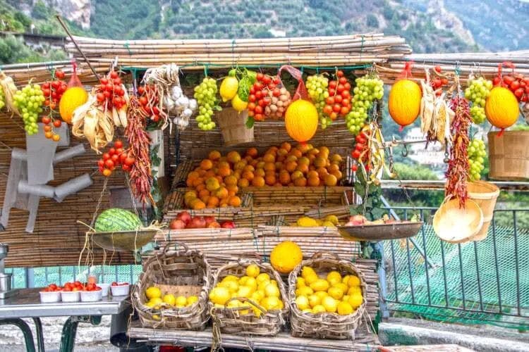 A cart of fruit including lemons, oranges and melons