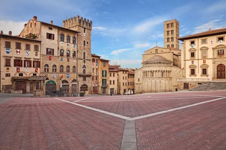 Arezzo town square with town hall, tower and church around the edge