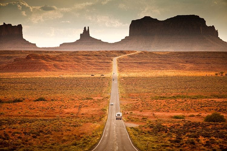 A long straight road through Monument Valley
