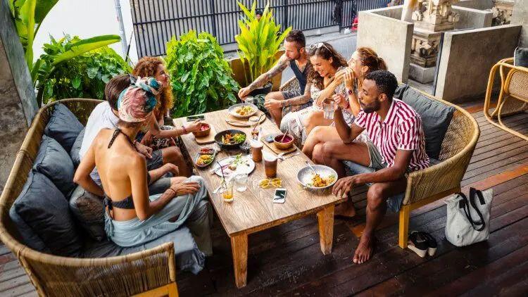 A group of friends seated around a table sharing food