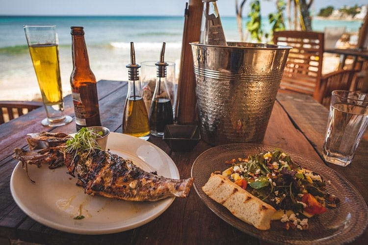 Plates of grilled fish, salad and bread at a Barbados restaurant