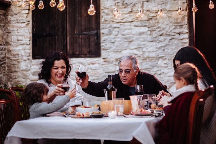 A family toasting glasses of red wine at a restaurant table