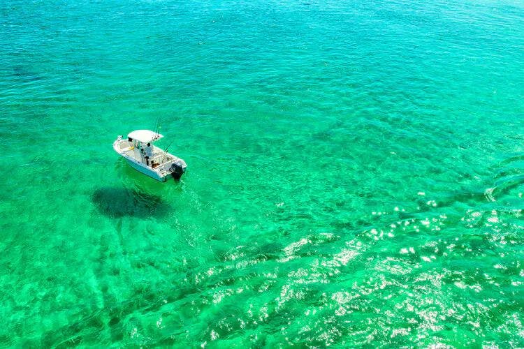 A small boat floating in clear sea water