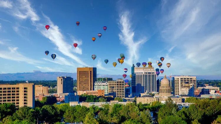 Hot air balloons floating over skyscrapers in a Idaho city