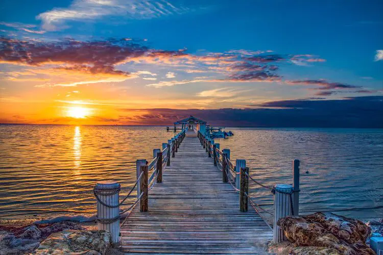 A wooden jetty into the water at sunset