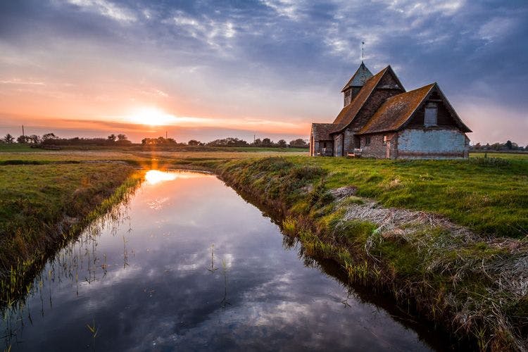 A old abandoned church by a canal in a Kent field