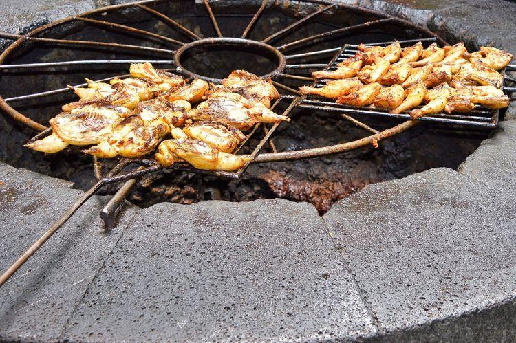 Cuts of meat being cooked by the heat of a volcano in Timonfaya National Park