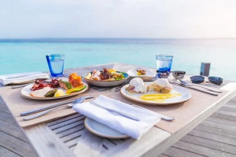 A table set with breakfast food by the sea