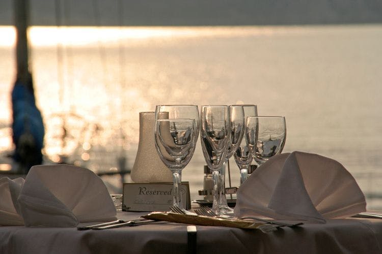 Lakeside restaurant set with wine glasses and napkins