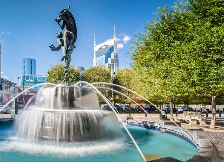 Fountain in a public park in Nashville with skyscraper buildings behind
