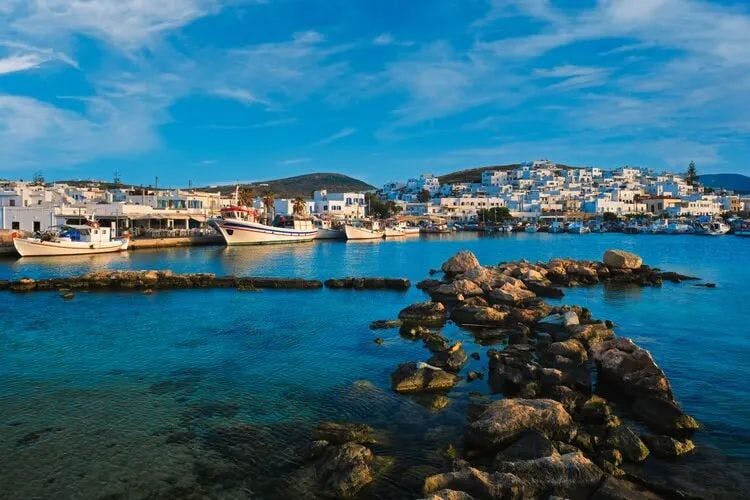 Village on the seafront in Paros with fishing boats in the harbor