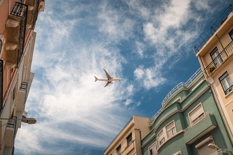 Airplane flying over buildings in Lisbon