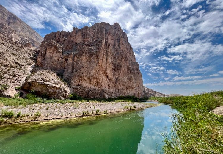 Dramatic Texas landscape with a river winding past a soaring rock formation
