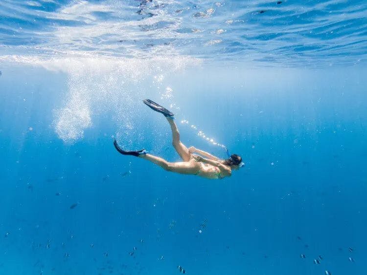 A woman swimming beneath the waves