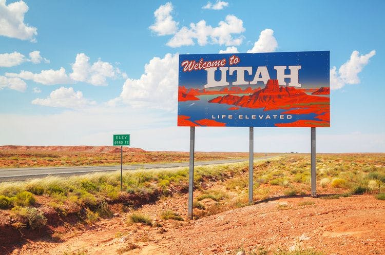 Sign reading 'Welcome to Utah' against desert backdrop