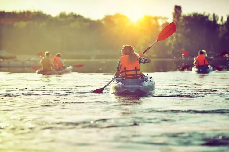 A group of kayaks on the water at sunrise