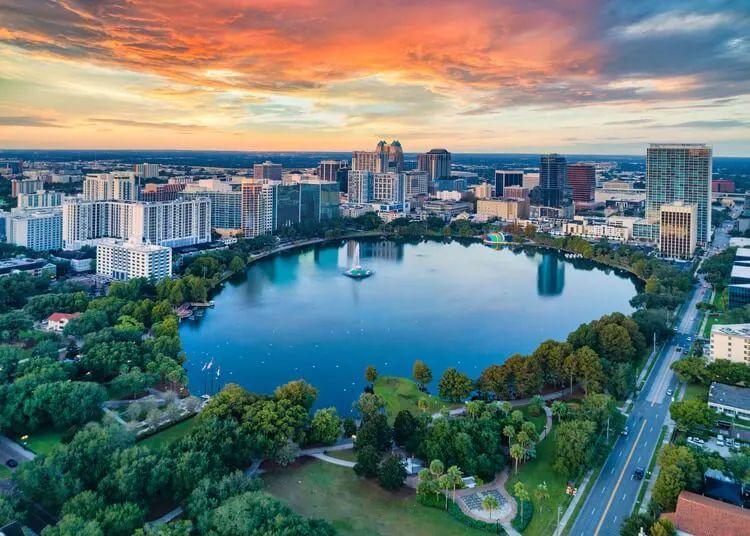 Large lake surrounded by trees amongst the skyscrapers of Downtown Orlando
