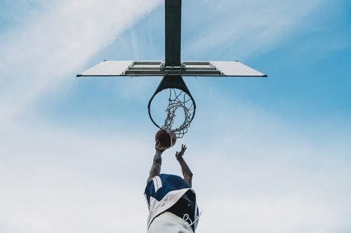 A person dunking a basketball in a hoop