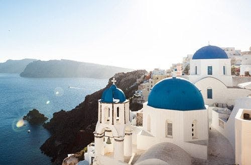 Oia town in Santorini with blue-domed churches overlooking the Aegean Sea