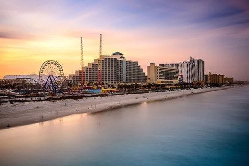 Daytona Beach, Florida, with skyscrapers and a big wheel on the white sand