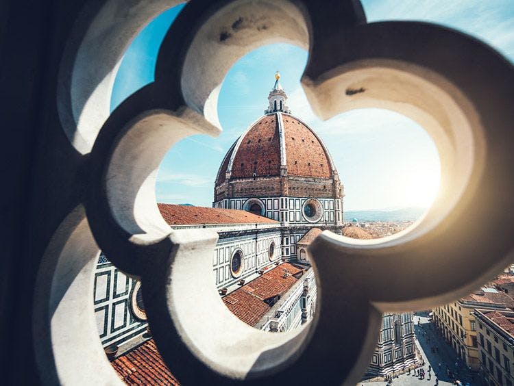 A view of Florence cathedral through an ornate window detail