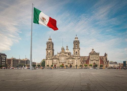 The Mexican flag flying in a square in Mexico City
