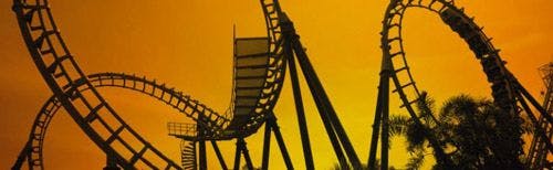 A looping rollercoaster track against an orange sky