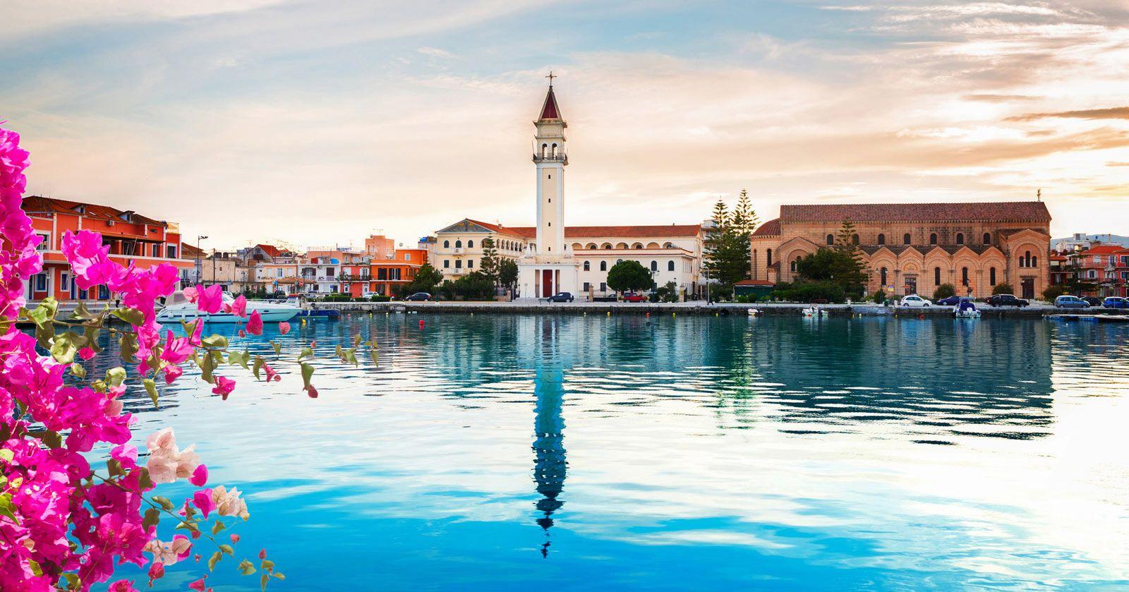 Zante town - reflection of church in the harbor with pink bougainvillea flowers in the foreground
