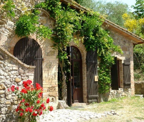 Tenuta Le Sodole - Glicine Tuscany villa exterior with stone walls and climbing green vines